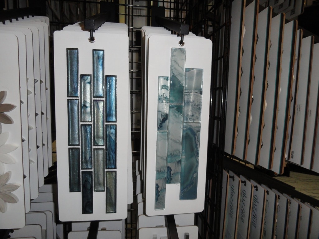 Blue iridescent glass tile sample cards on showroom rack